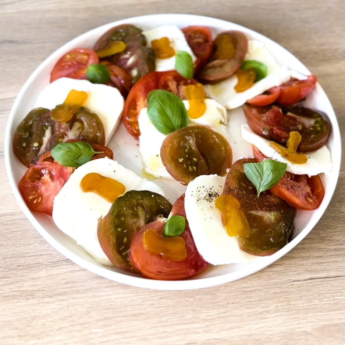 assiette de tomates mozzarella avec boutargue memmi au citron confit