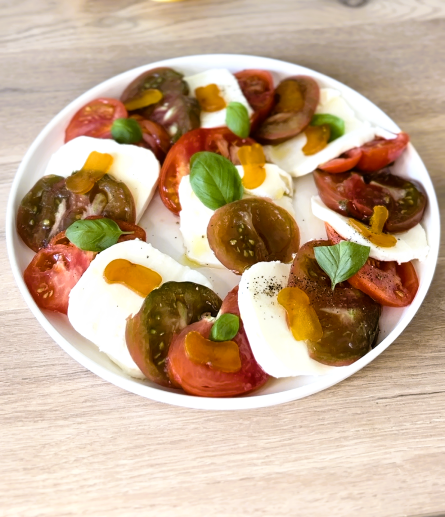 assiette de tomates mozzarella avec boutargue memmi au citron confit